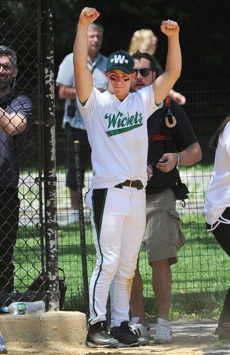 Nick Jonas levantando los brazos después de jugar beisbol 