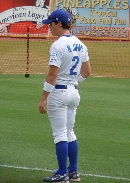 Nick Jonas parado de espaldas mientras juega beisbol