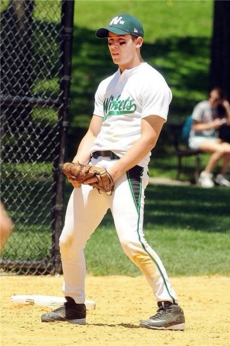 Nick Jonas jugando beisbol mientras sujeta un guante
