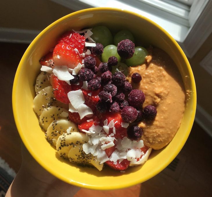 Tazón de fruta con plátano fresa y uvas verdes