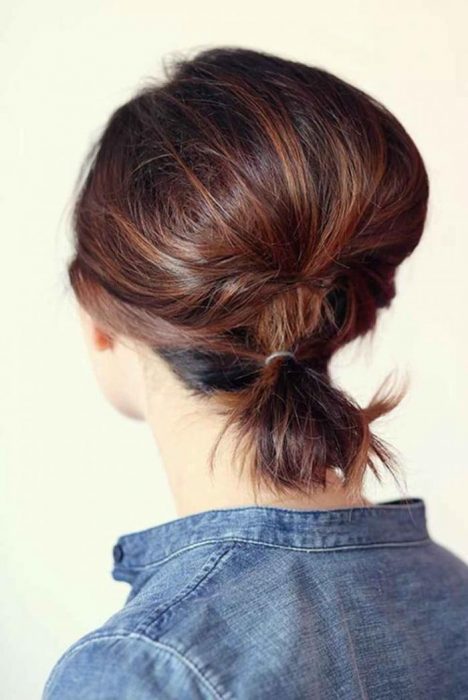 Chica con el cabello corto atado en una coleta baja 