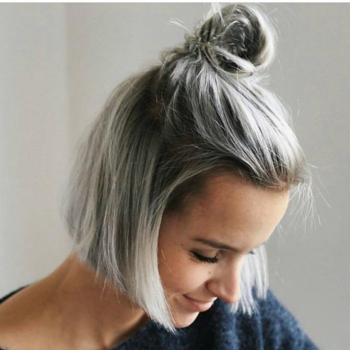 Chica con el cabello corto atado en un bun 