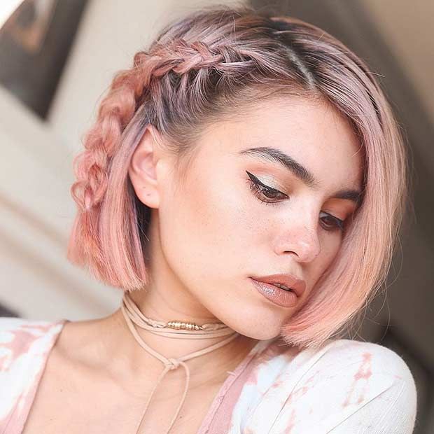 Chica con el cabello rosa atado a un lado con un trenza 