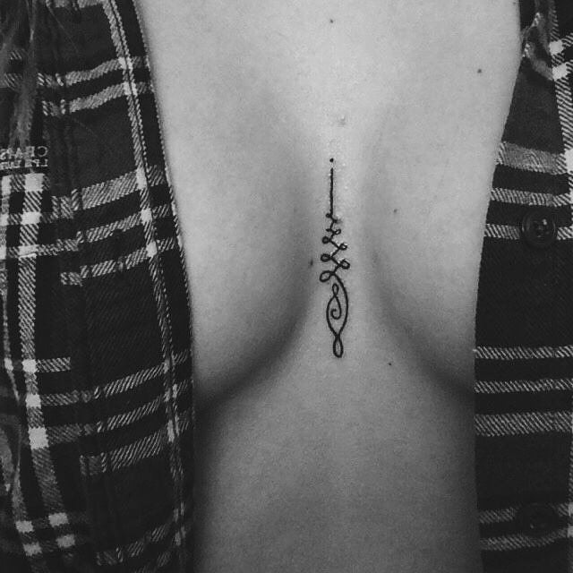 Chica con un tatuaje en medio de su escote 