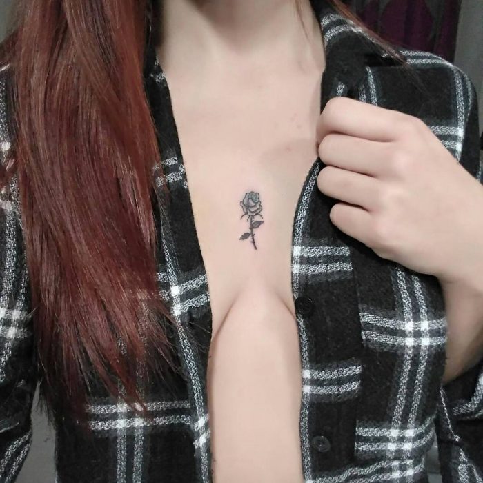 Chica con un tatuaje en medio de su escote 