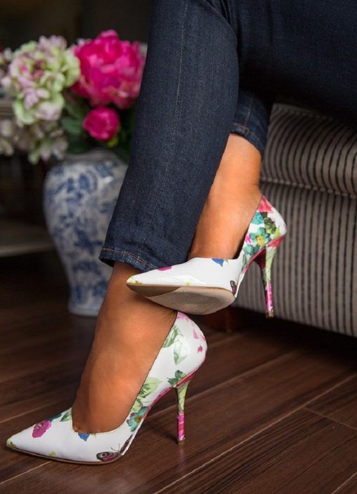 Chica usando unos stilettos blancos con flores 