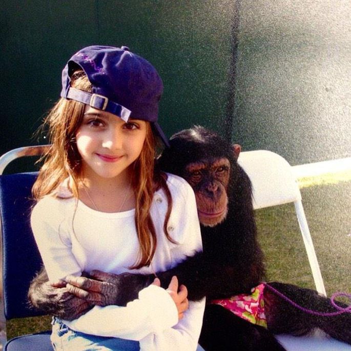 niña con gorra y chimpancé