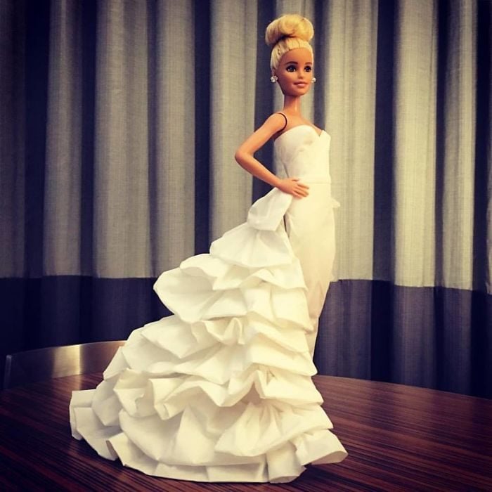 Muñeca barbie usando un vestido blanco de novia hecho con papel higiénico 