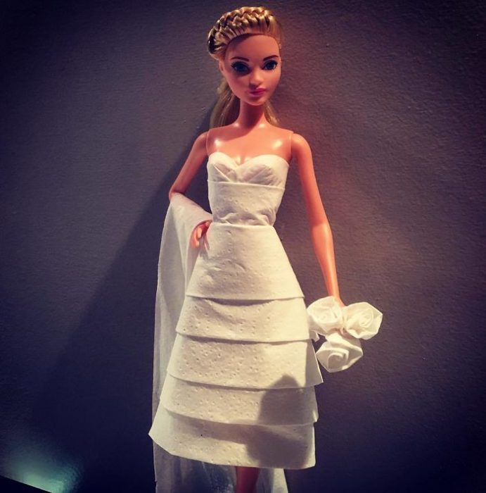 Muñeca barbie usando un vestido blanco de novia hecho con papel higiénico 