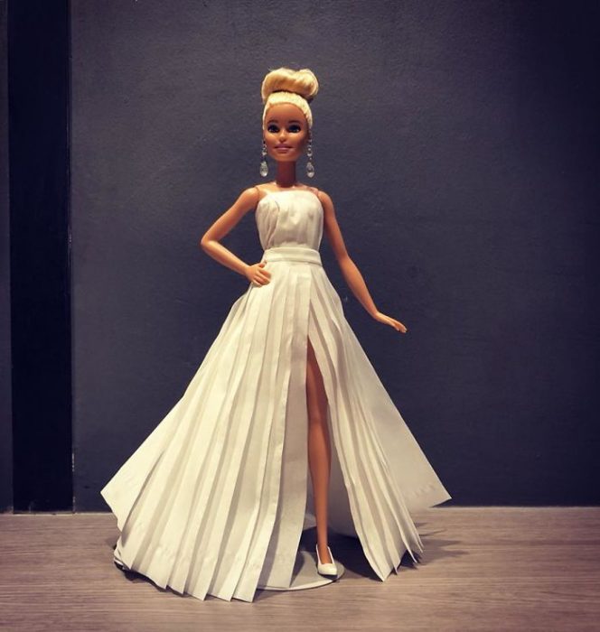 Muñeca barbie usando un vestido blanco de novia hecho con papel higiénico 