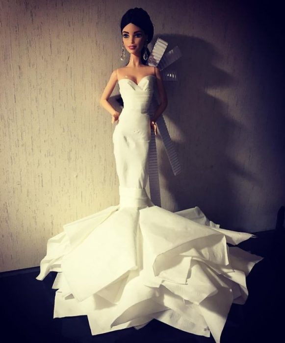 Muñeca barbie usando un vestido blanco de novia hecho con papel higiénico 