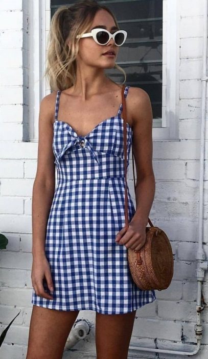 Chica usando un bolso straw handbags con un vestido azul de cuadros