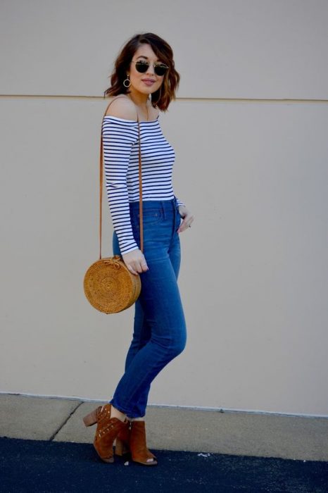 Chica usando un bolso straw handbags con jeans y blusa de rayas 