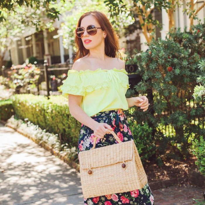 Chica usando un bolso straw handbags con falda de flores y blusa amailla