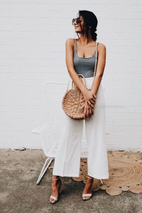 Chica usando un bolso straw handbags con pantalones de campana y blusa cuadrada 