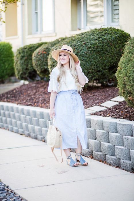 Chica usando un bolso straw handbags con falda y blusa a rayas 