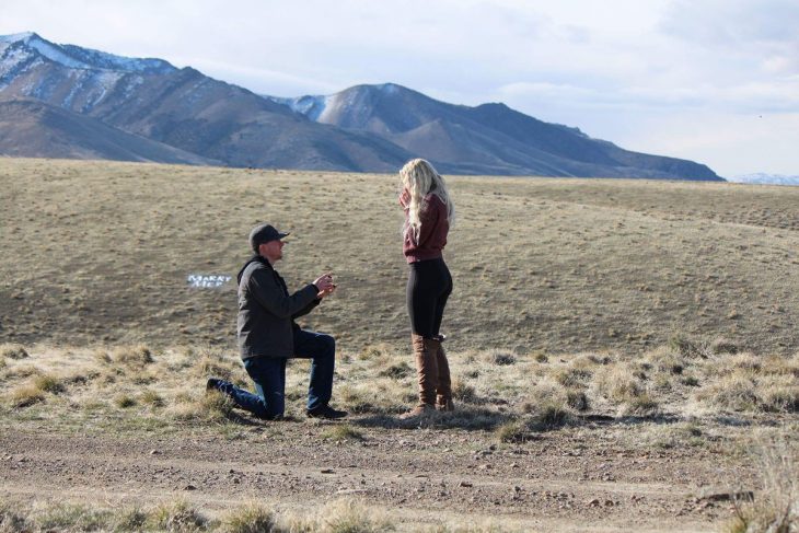 Hombre arrodillado proponiendo matrimonio a una chica