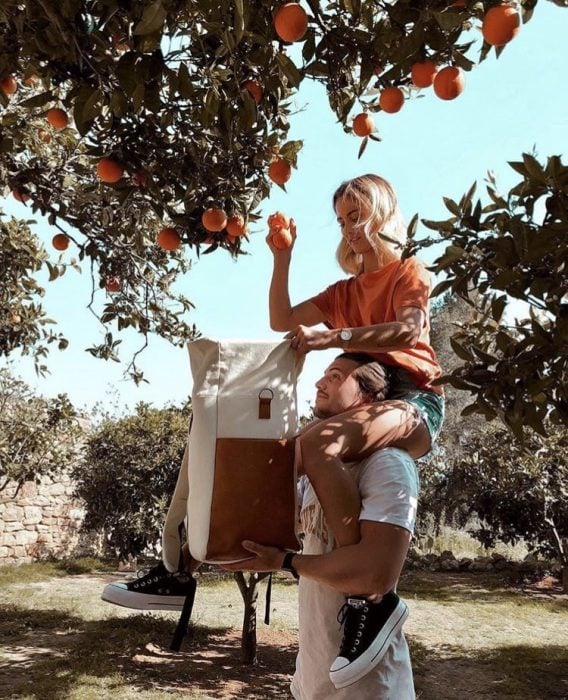 pareja de novios recolectando naranjas 