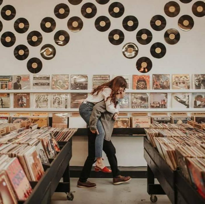 pareja de novios jugando en una tienda de discos