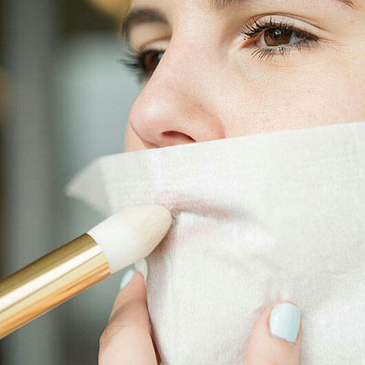 Chica aplicando polvo traslucido en los labios