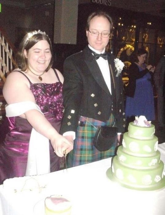 Pareja de novios cortando su pastel de bodas