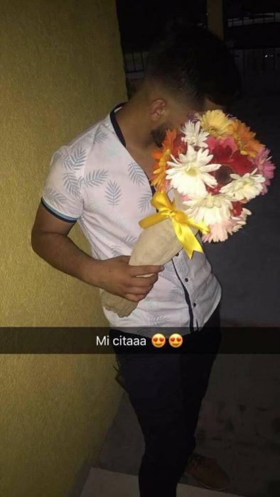 Chico sosteniendo un ramo de flores para sorprender a su novia el día de su cumpleaños 