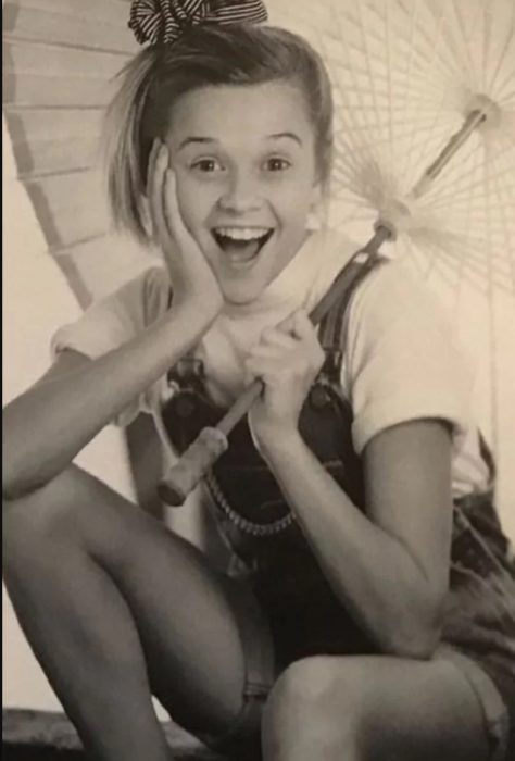Reese Witherspoon sujetando una sombrilla cuando era niña 