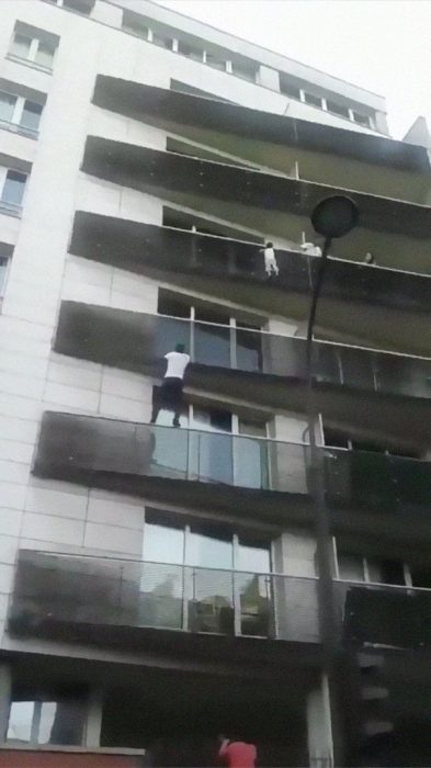 Hombre escalando un balcón para salvar a un niño de caer 