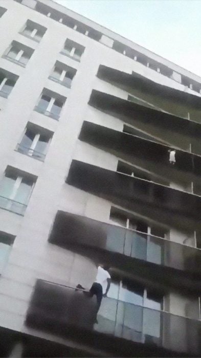 Hombre escalando un balcón para salvar a un niño de caer 