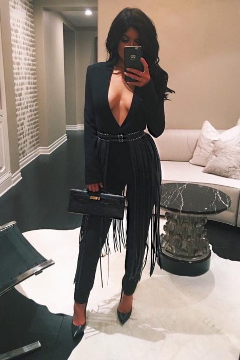 Chica usando un jumpsuit de color negro con un cinturón de correas 