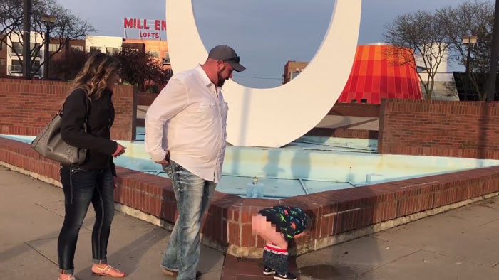 Niño haciendo pipi mientras sus padres se besan en una propuesta de matrimonio 