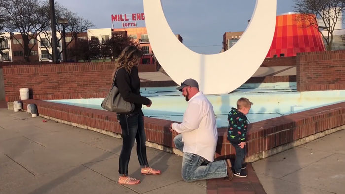 Niño haciendo pipi mientras sus padres se besan en una propuesta de matrimonio 