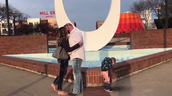 Niño haciendo pipi mientras sus padres se besan en una propuesta de matrimonio 