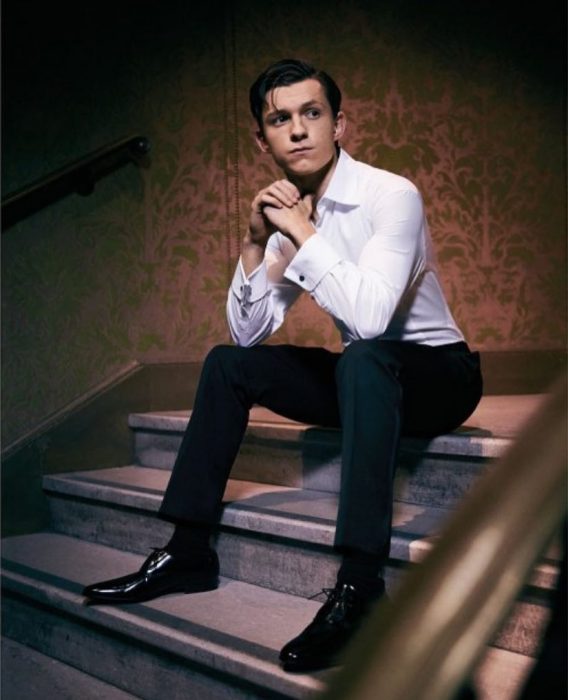 chico sentado en las escaleras usando traje sastre 