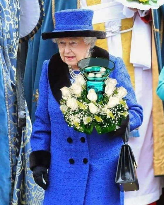 Reina Isabel sosteniendo un adorno de mesa 