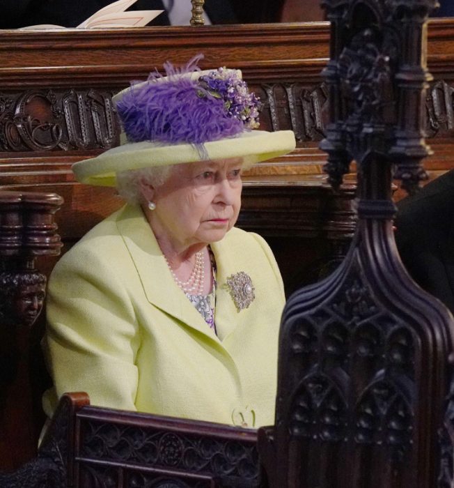 Reina Isabel ll usando un sombrero verde con toques morados en la boda real 