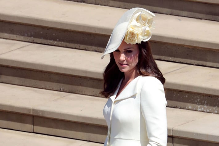 Kate Middleton usando un sombrero de color amarillo con flores 
