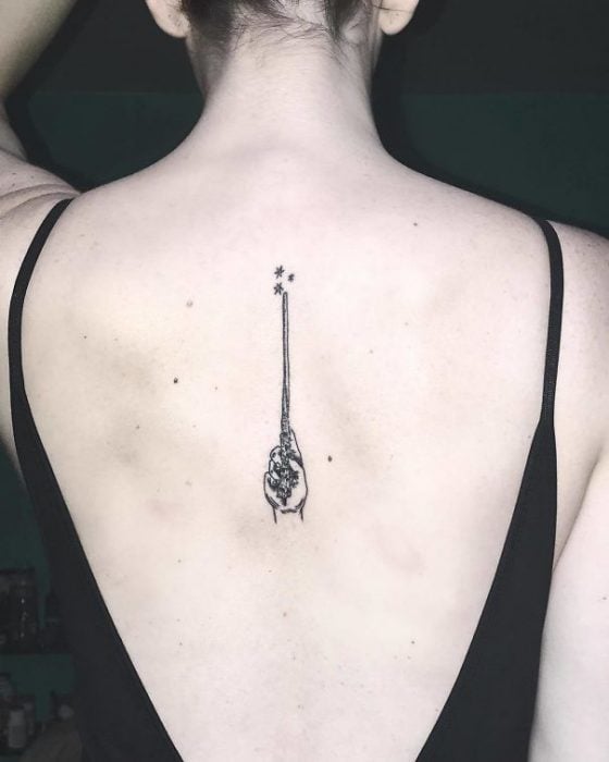 Tatuaje en la espina dorsal con diseño de varita de Harry Potter 