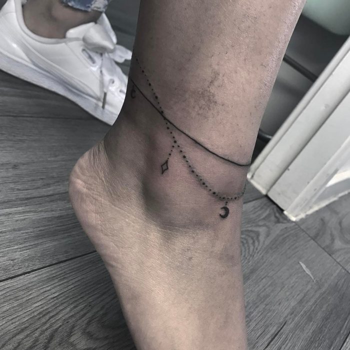 Tatuaje en el tobillo en forma de pulsra con piedras 