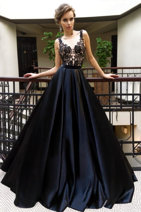 Chica usando un vestido de color negro con escote y pecho de encaje