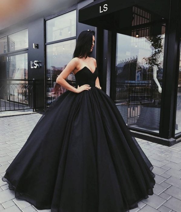 Chica usando un vestido de color negro con mucho volumen 