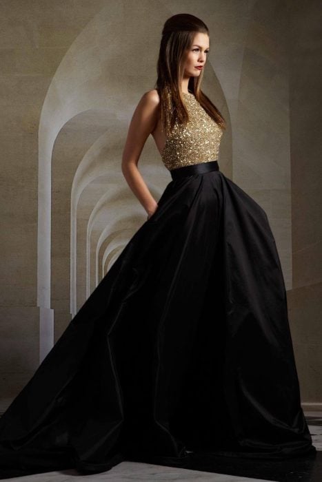 Chica usando un vestido de color negro con dorado 