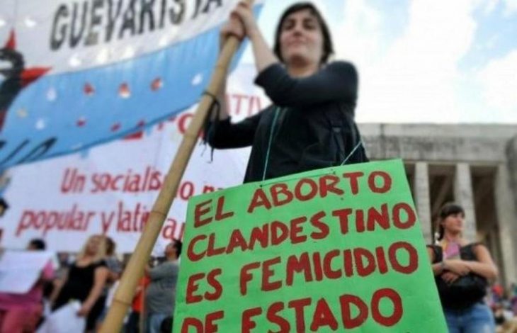 mujer con bandera y pancarta aborto 