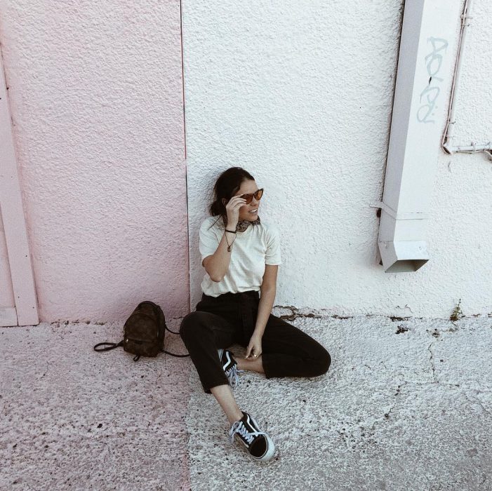 mujer sentada en el suelo en la pared 