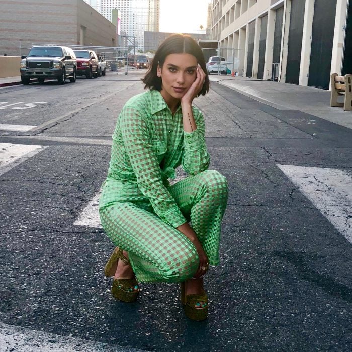 mujer incada en la calle con traje verde 