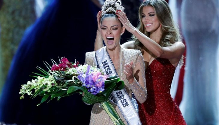 Ganadora de miss america usando una corona y sosteniendo un ramo de flores 