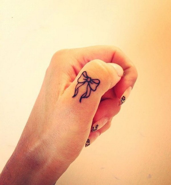Tatuaje de un moño en el dedo pulgar 