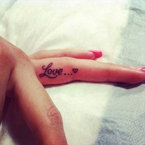 Tatuaje que dice amor en el dedo medio