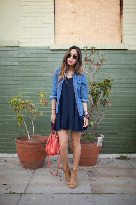 Chica para en la calle usando un vestido azul y bonites café 