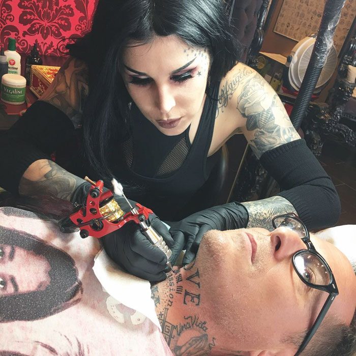 Mujer tatuadora tatuajdo a hombre en el cuello
